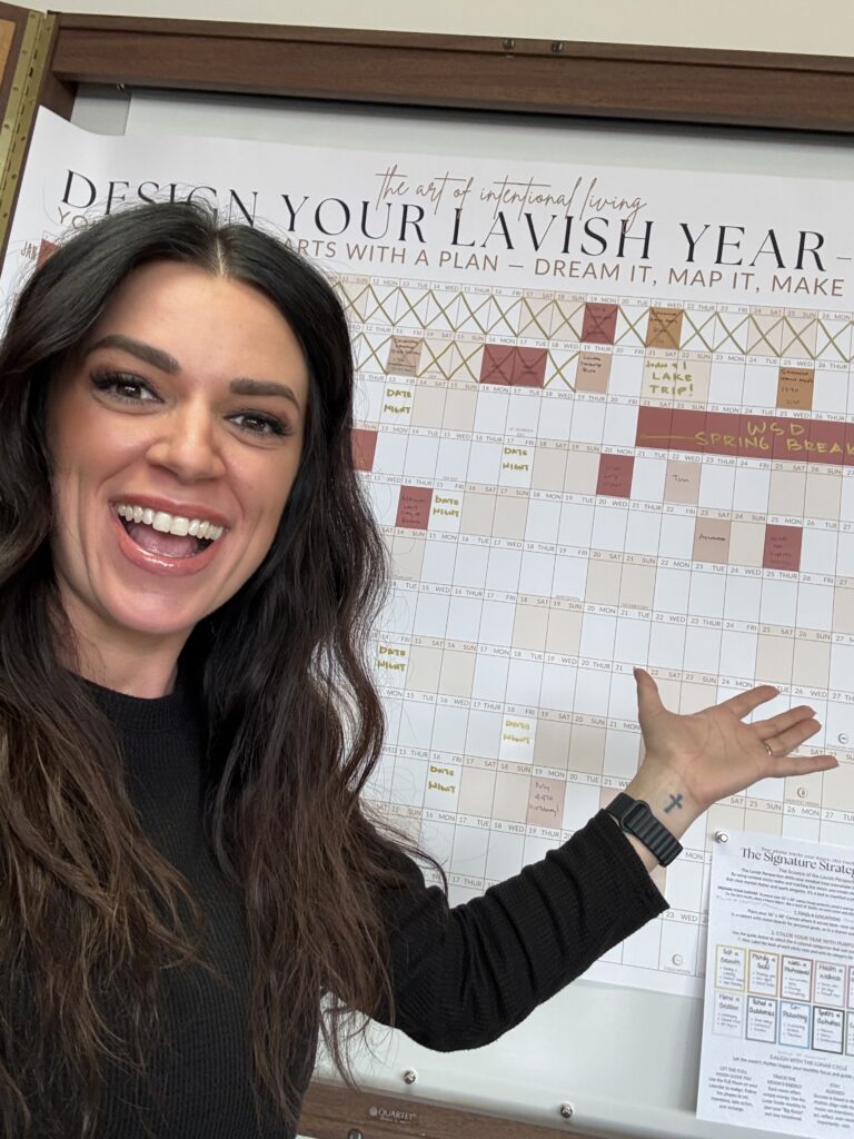 Founder of Lavish Interiors pointing to the 3ft x 4ft 2026 Signature Wall Calendar, showing the massive scale and design-forward layout of the lunar planning system.