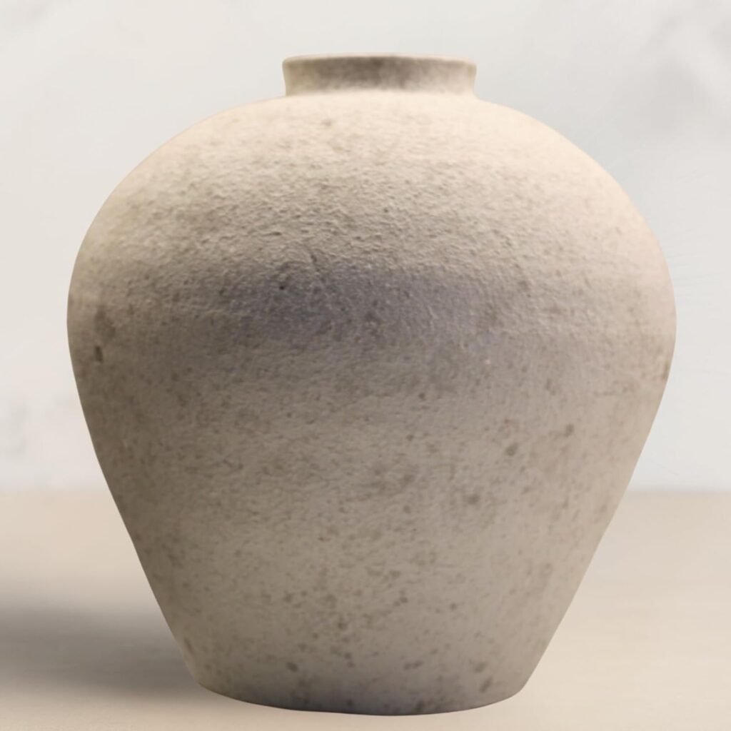 Large round stone-textured vessel on a minimalist white pedestal.