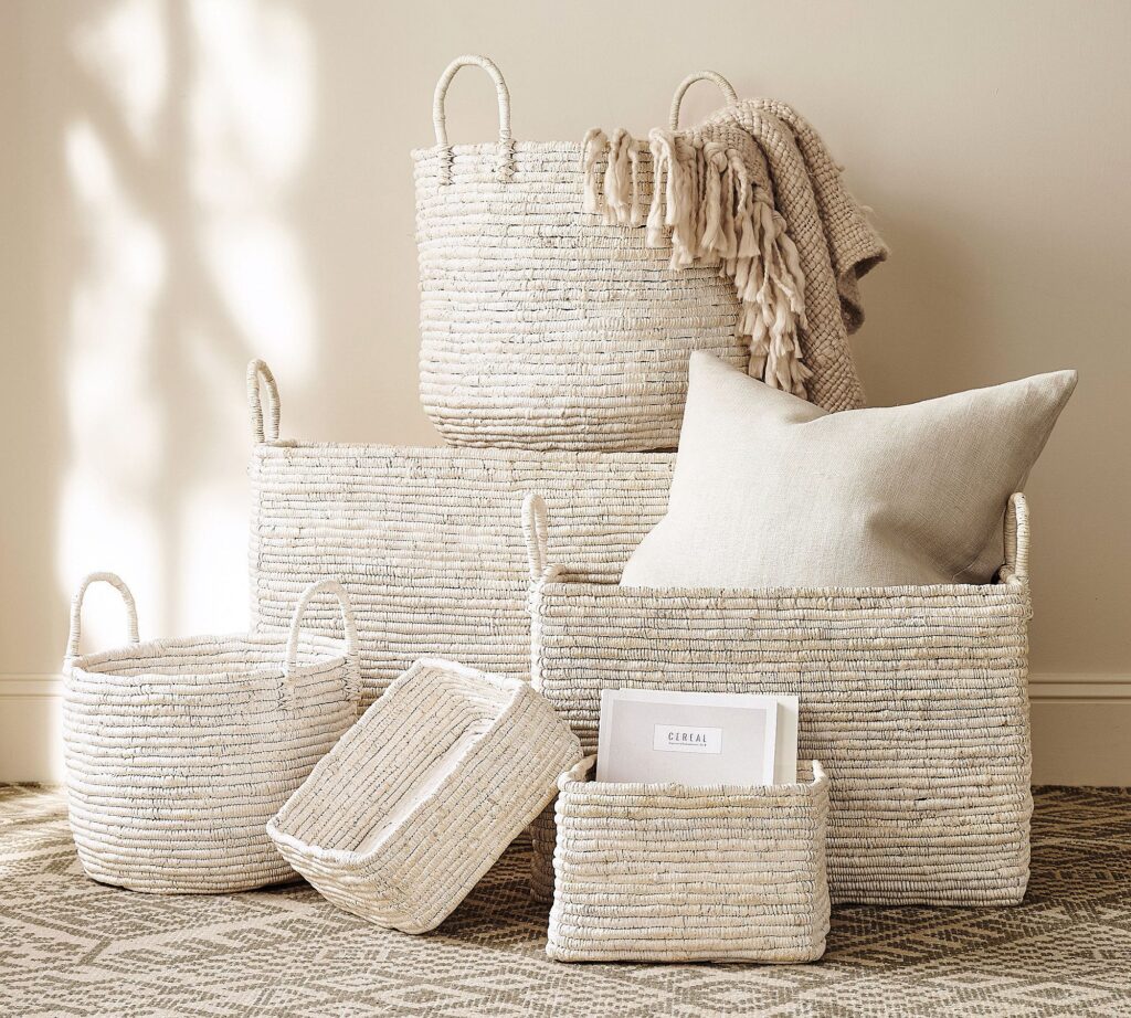 A set of two hand-coiled white decorative nesting baskets with organic, irregular edges on a clean white surface.