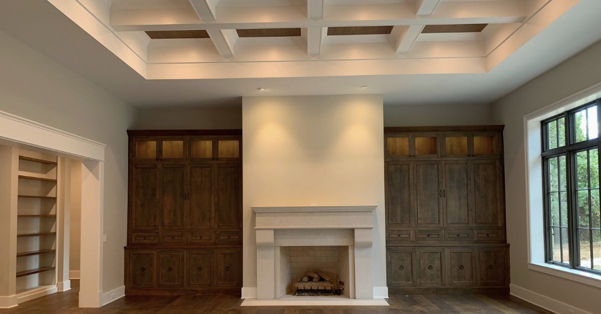 Elegant living room with a grand stone fireplace and warm neutral furnishings, designed by a luxury interior designer in St. Louis.