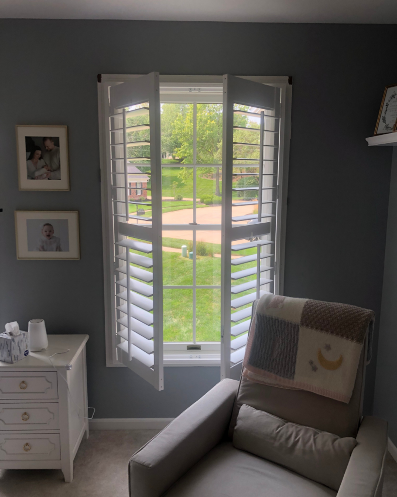 Muted plantation shutters open in a bright residential nursery by St Louis Blinds and Shutters.