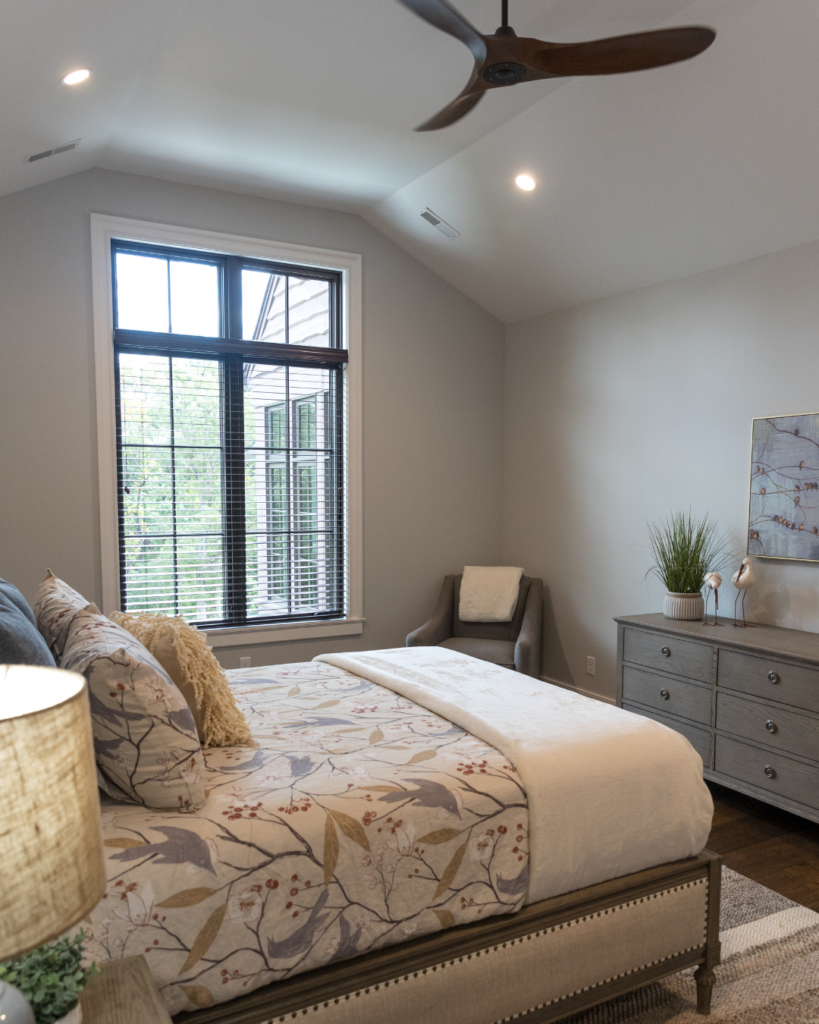 Serene custom bedroom suite with vaulted ceilings and large black-framed windows in St. Louis.