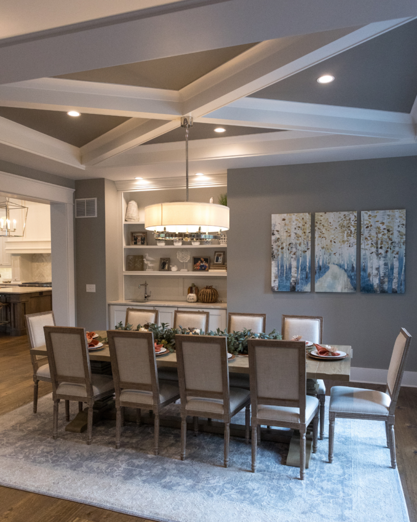 Custom dining room with neutral tones, large dining table, and rug in a luxury St. Louis home.