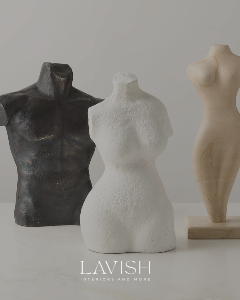 Three minimalist ceramic and marble abstract torso sculptures styled on a white marble surface.
