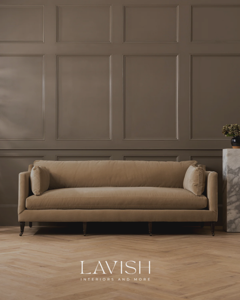 A luxurious olive brown board and batten accent wall behind a velvet sofa with a marble plinth side table.